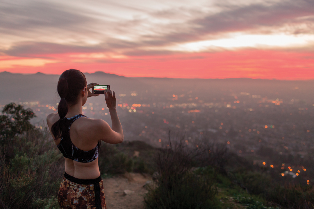 Жена снима градски пейзаж с мобилен телефон